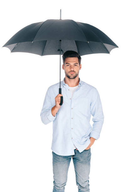istock handsome bearded young man holding umbrella and looking at camera isolated on white 1048257656