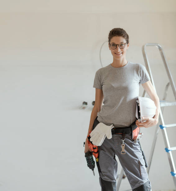 istock Professional repairwoman posing and holding a drill 1048265234