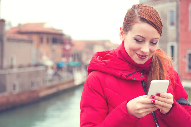 istock Cheerful woman using phone on street 1048265346