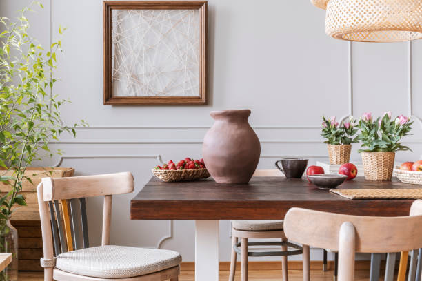 sillas de madera en mesa con jarrón y flores en interior de comedor gris con cartel. foto real - slow jam fotografías e imágenes de stock