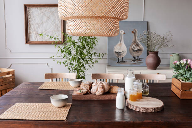 lámpara de sobre mesa de madera con comida y cuencos en interior comedor gris con carteles. foto real - slow jam fotografías e imágenes de stock