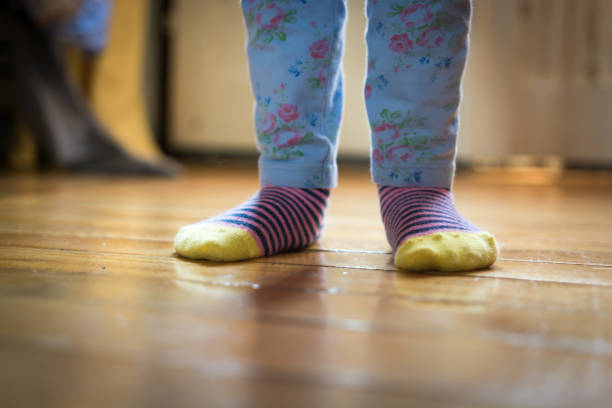 istock Small baby feet on a parquet floor 1048275566