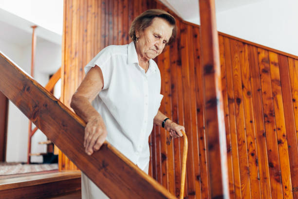 istock Elderly woman at home using a cane to get down the stairs 1048276230