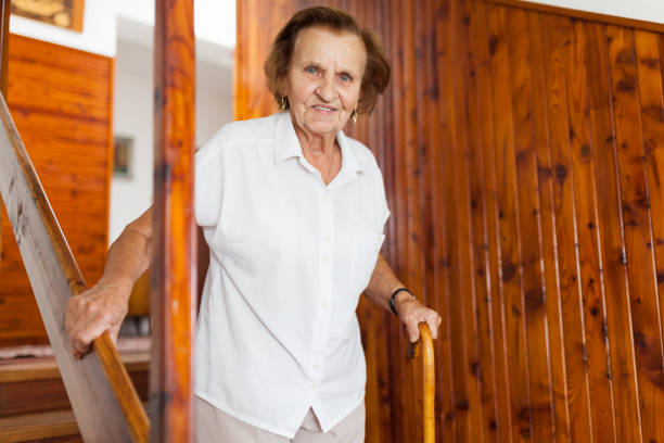istock Elderly woman at home using a cane to get down the stairs 1048276566