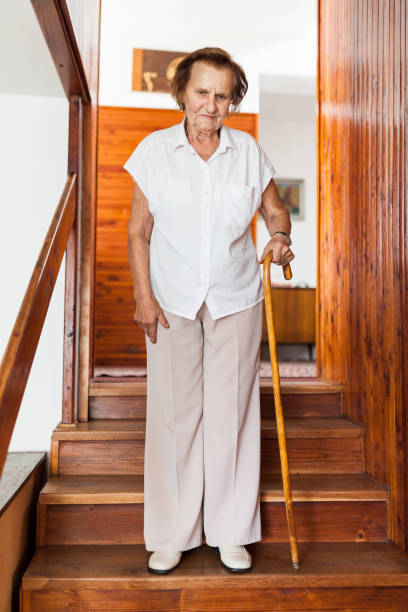 istock Elderly woman at home using a cane to get down the stairs 1048276978