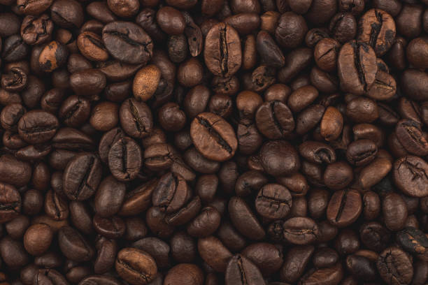 chicchi di caffè arrostiti. sfondo, vista dall'alto ravvicinato. colazione sana. - coffee bean caffeine macro food foto e immagini stock