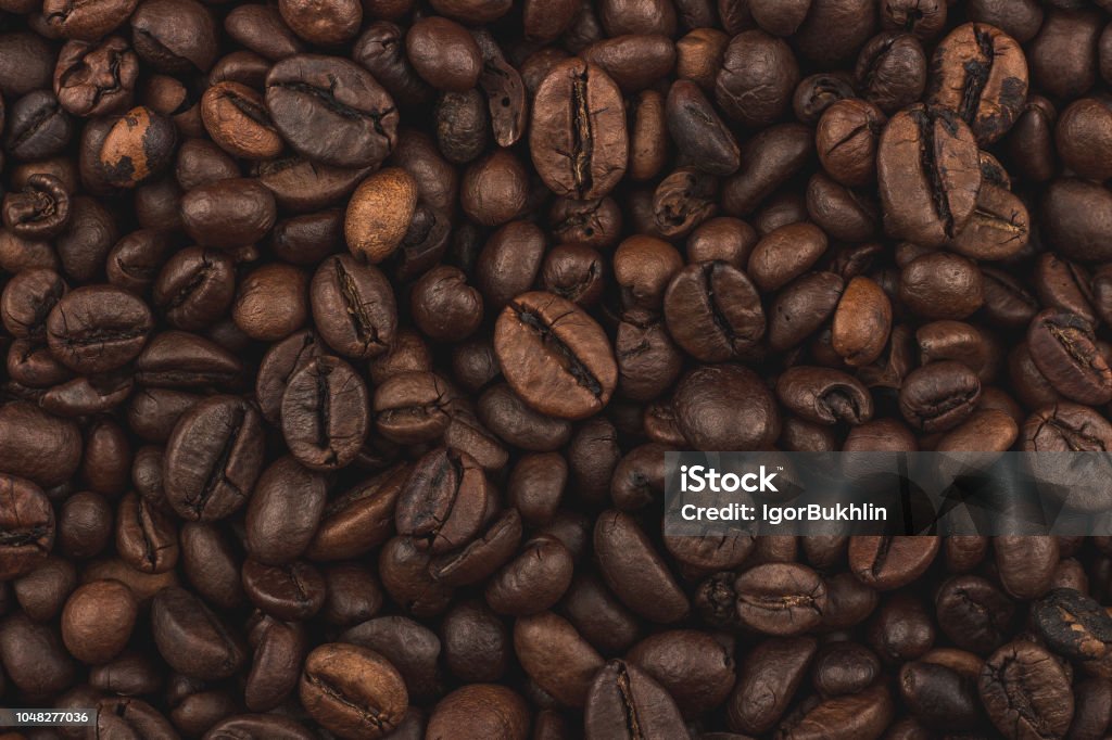 Roasted coffee beans. Background, close-up top view. Healthy breakfast. Fresh coffee grains wallpaper. Good morning. Coffee shop. Coffee - Drink Stock Photo