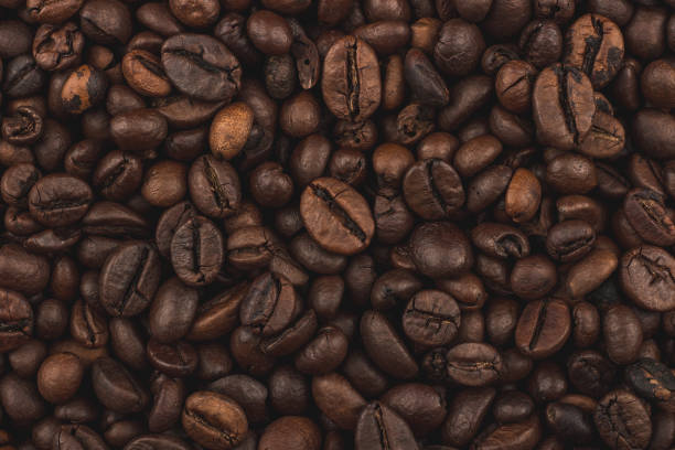 Roasted coffee beans. Background, close-up top view. Healthy breakfast. Fresh coffee grains wallpaper. Good morning. Coffee shop. texture cafe stock pictures, royalty-free photos & images