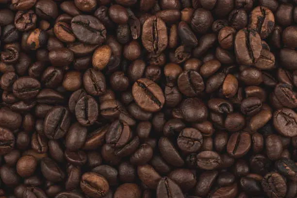 Photo of Roasted coffee beans. Background, close-up top view. Healthy breakfast.