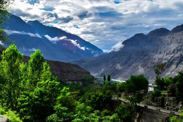 Beautiful Nature Landscape with blue Tint Mountains range and dark smoky clouds in Gilgit Pakistan.