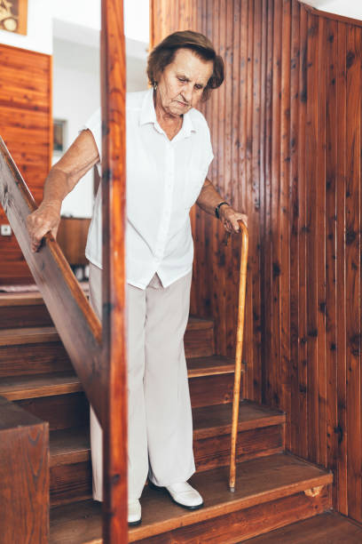 istock Elderly woman at home using a cane to get down the stairs 1048278496