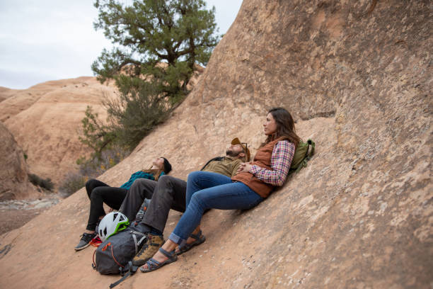istock A group of adventurous friends rest against a smooth rock formation while hiking through the rough Entrajo Trail in Moab, Utah. 1048280636