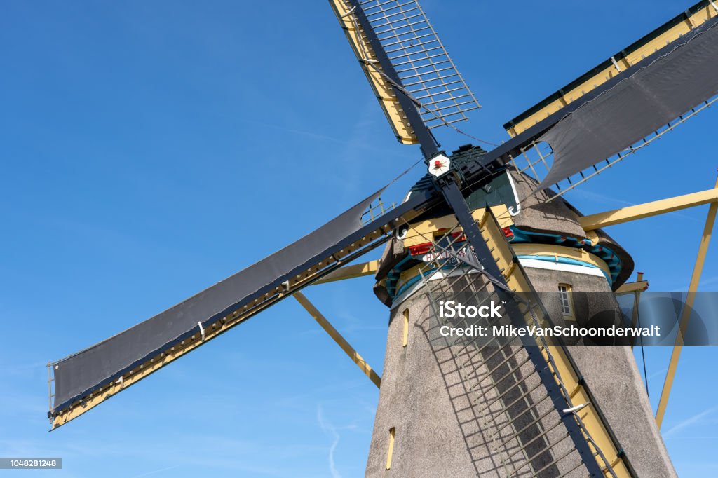 Traditional wind mill in a typical dutch rural landscape Many traditional windmills can still be found in the Netherlands. formerly they were used to grind grain into flour or to regulate the drainage of water. Today they are mainly a touristic attraction. Agriculture Stock Photo