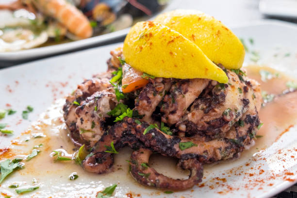 свежевыловленный осьминог на гриле с чесноком и оливковым маслом и подается с винным соусом - octopus seafood malta catch of fish стоковые фото и изображения