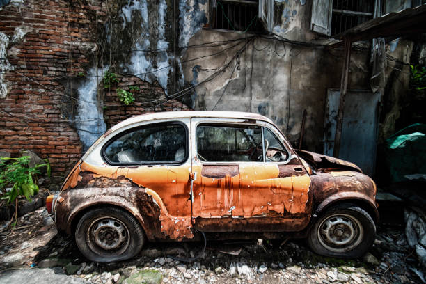 istock Rusty old car abandoned beside old house 1048295222