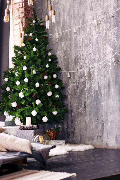 istock A spacious empty bedroom in a loft style with a decorated Christmas tree and a garland. 1048296706