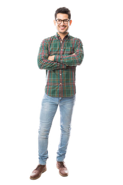 Full length of young man standing arms crossed over white background
