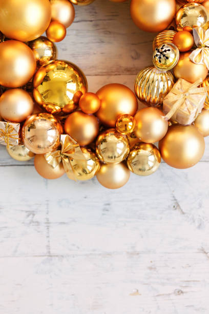 istock Christmas gold wreath on white wooden background 1048301162