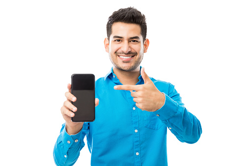Portrait of smiling male showing off his new mobile phone against white background