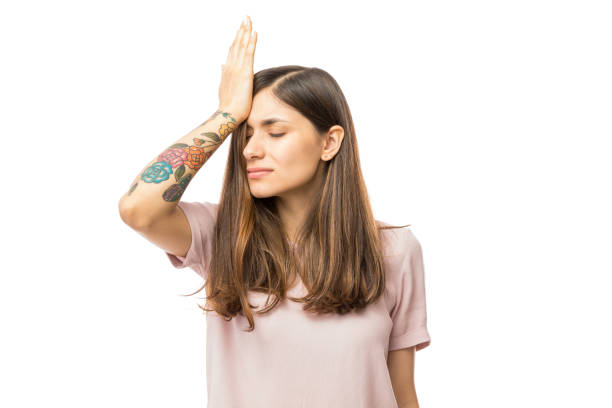 Woman Realizing Mistake And Keeping Hand On Head Woman realizing mistake and keeping hand on head over white background regret stock pictures, royalty-free photos & images