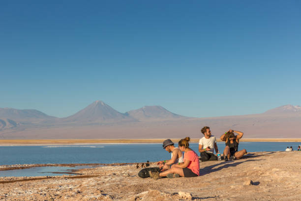 Young couples in Chile. Young couples sitting in front of the Atacama Salar, relaxing moment, the Andes mountains range in the background, Chile. chile tourist stock pictures, royalty-free photos & images