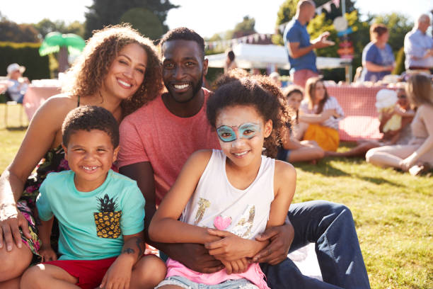 portrait de famille avec des enfants assis sur des tapis au jardin d’été fete - divertissement événement photos et images de collection