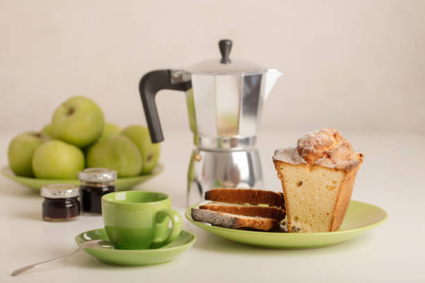 Breakfast - coffee and cupcake in a green bowl on a white background. Selective focus.