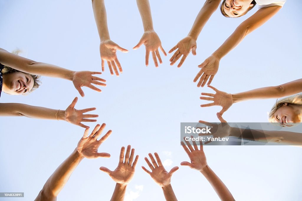 Circle of girlfriends making a star with their arms hands of young people stretching to the center Activity Stock Photo