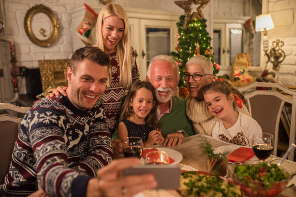 istock Man taking a selfie with family over dinner 1048336102
