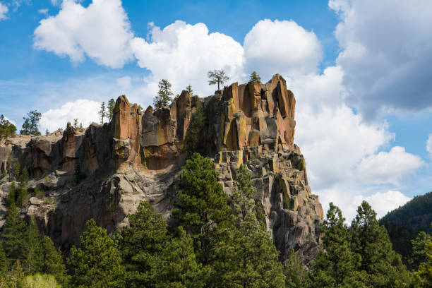 Craggy, rugged rock formation under a blue sky with puffy white clouds
