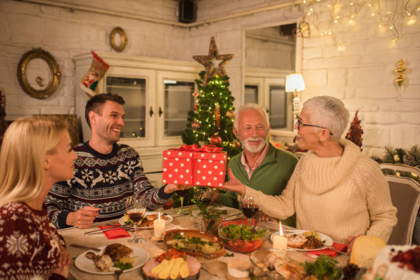 istock Family holding present at Christmas dinner 1048346070