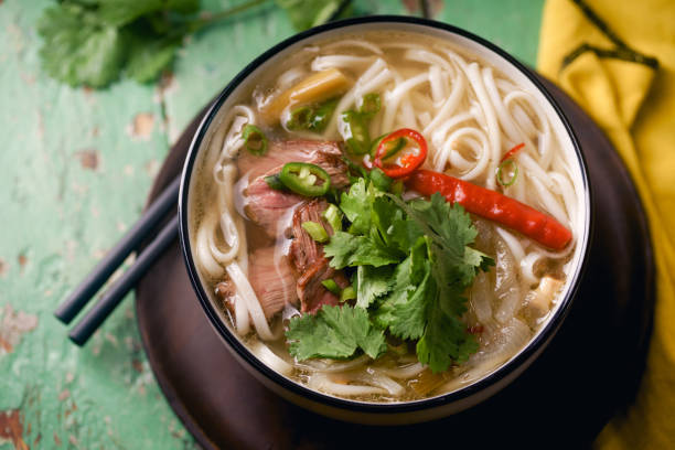 istock Vietnamese traditional soup Pho Bo with beef and fresh coriander on rustic wooden table 1048349976
