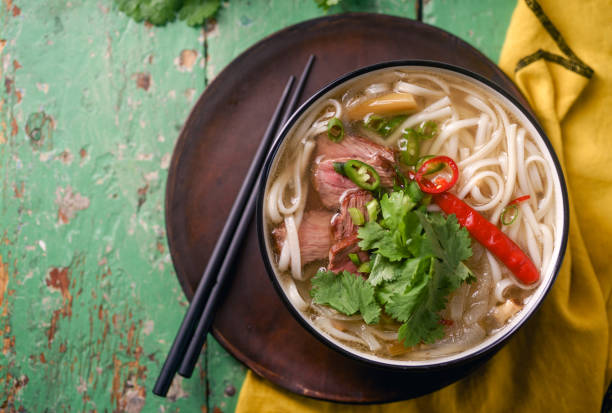 istock Vietnamese traditional soup Pho Bo with beef and fresh coriander on rustic wooden table 1048349994