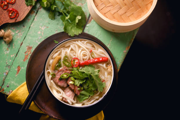 istock Vietnamese traditional soup Pho Bo with beef and fresh coriander on rustic wooden table 1048350010