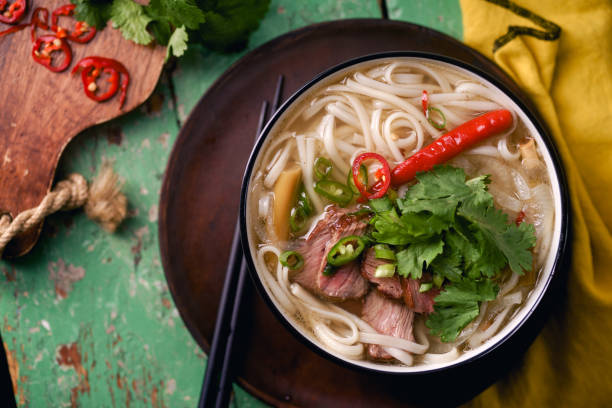 istock Vietnamese traditional soup Pho Bo with beef and fresh coriander on rustic wooden table 1048350032