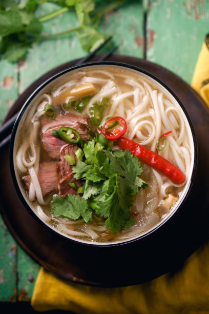 istock Vietnamese traditional soup Pho Bo with beef and fresh coriander on rustic wooden table 1048350034