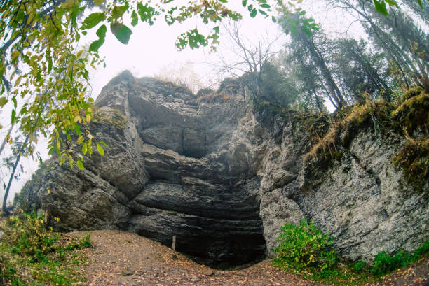 istock Autumn landscape: rocks in the forest, grotto, cave . Parking ancient man in the wild. 1048352674