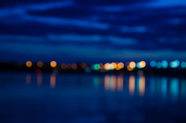 Blurred city lights with bokeh effect reflected on water