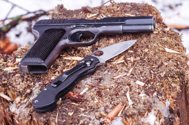 istock Black pistol and black knife. Knife with a hole. 1048367032