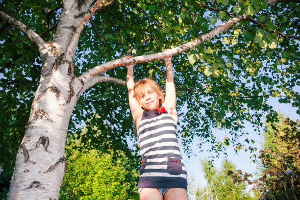 istock Happy girl hanging from a tree in a summer park 1048372078