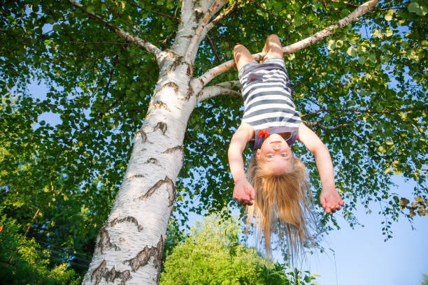 istock Happy girl hanging from a tree in a summer park 1048372092