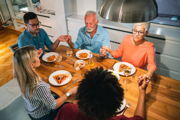 istock Family prays before eating dinner 1048376142