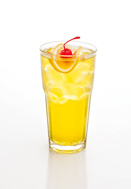 istock yellow cocktail decorated with cherry and lemon isolated on white. 1048379494
