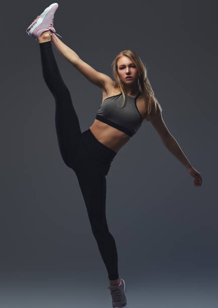 istock Beautiful blonde girl stretches her legs before training. 1048380274