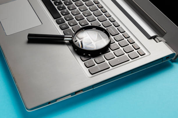 istock Laptop computer with magnifying glass on blue background, concept of search. Internet security conceptual image 1048387944