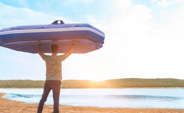 istock Man carrying a boat in nature 1048388008