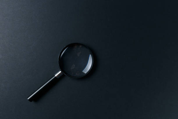 istock Magnifying glass on black texture background. Top view. Flat lay 1048390166
