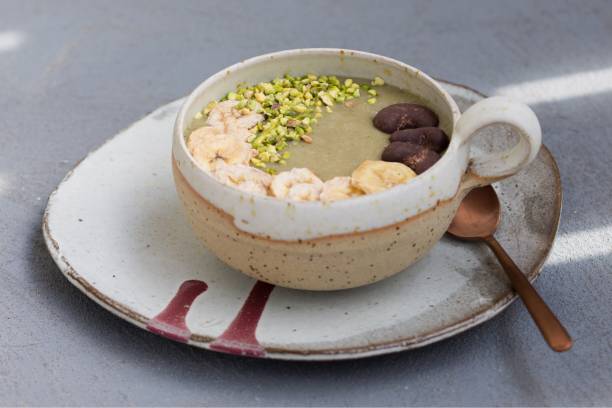 Healthy breakfast - smoothie bowl - banana, avocado, coconut milk with pistachios, chocolate cashews and dried bananas