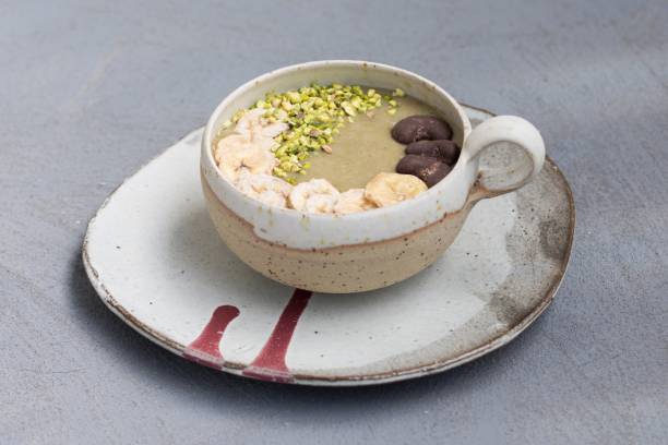 Healthy breakfast - smoothie bowl - banana, avocado, coconut milk with pistachios, chocolate cashews and dried bananas