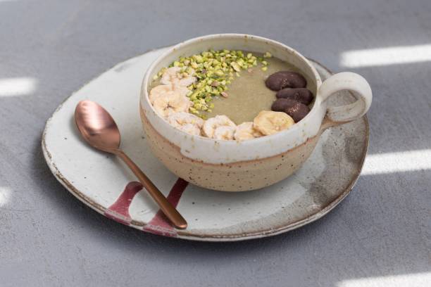 Healthy breakfast - smoothie bowl - banana, avocado, coconut milk with pistachios, chocolate cashews and dried bananas